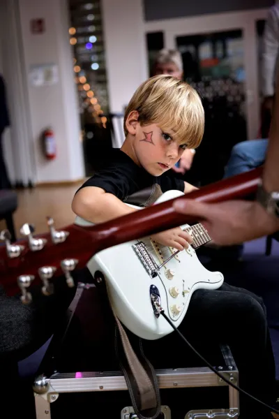En pojke testar gitarr på smash into peaces