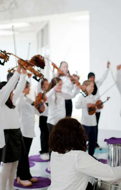 Bilden föreställer glada barn i vita skjortor som musicerar i grupp, dekorativ eventbild till evenemanget Kulturskolan på Kanalscenen