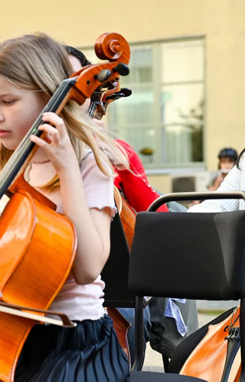 Bilden föreställer barn som spelar cello på scen. Dekorativ eventbild till Kulturskolan på Kanalscenen.