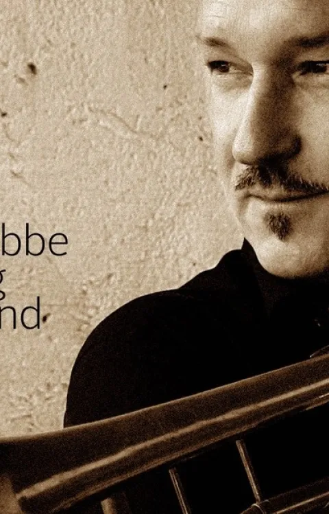 Porträtt av Peter Asplund med trumpet och Bobbe Big Bands logotyp