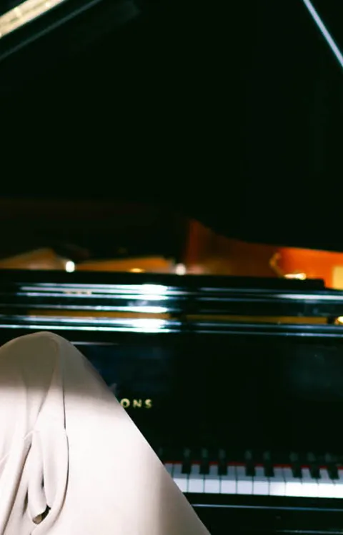 Person ler framför en mörk bakgrund