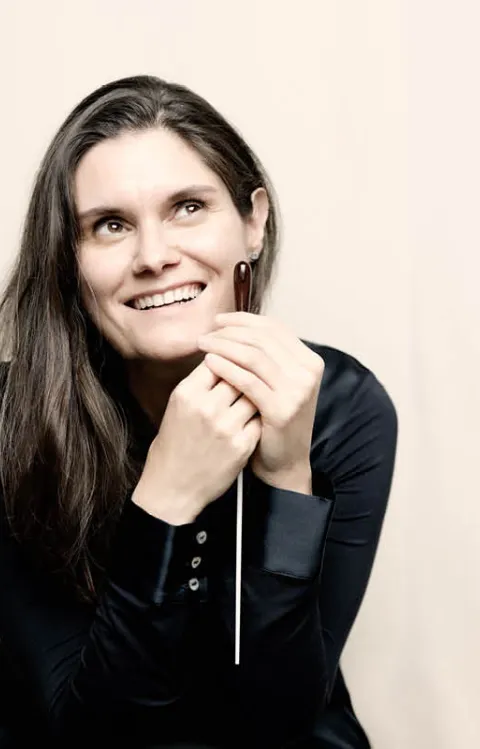 Person sitter på en bänk och håller ett tunt föremål i handen.