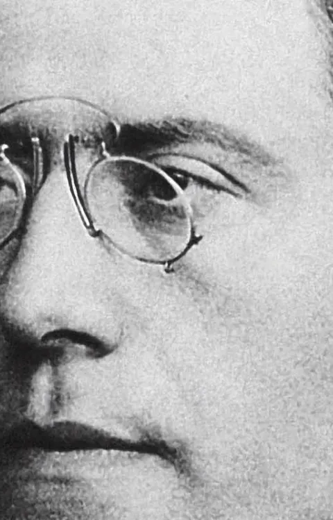 Svartvit bild på man där endast ansiktet syns