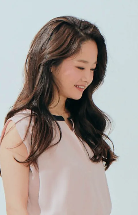 Person håller en violin mot sidan i en ljus studiobakgrund.