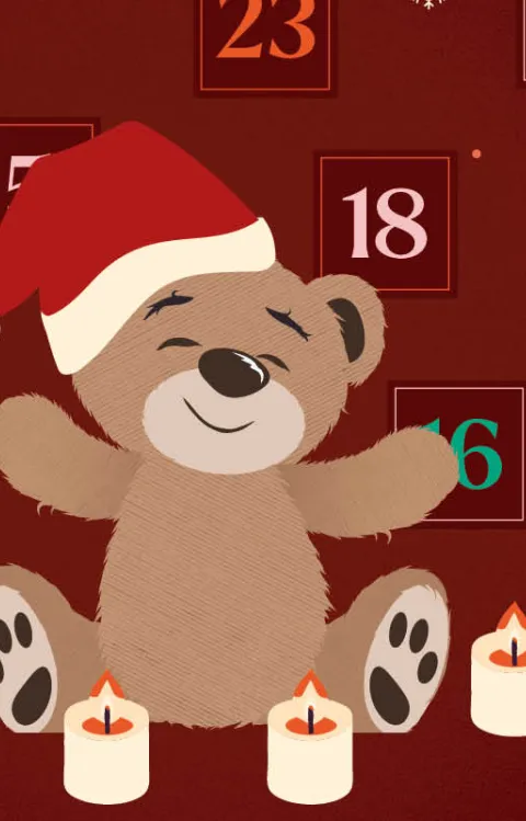 Nalle iklädd julmössa framför en mörkröd bakgrund