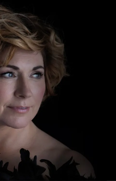 En bild på Sissel Kyrkjebö framför svart bakgrund till konserten Sissels jul