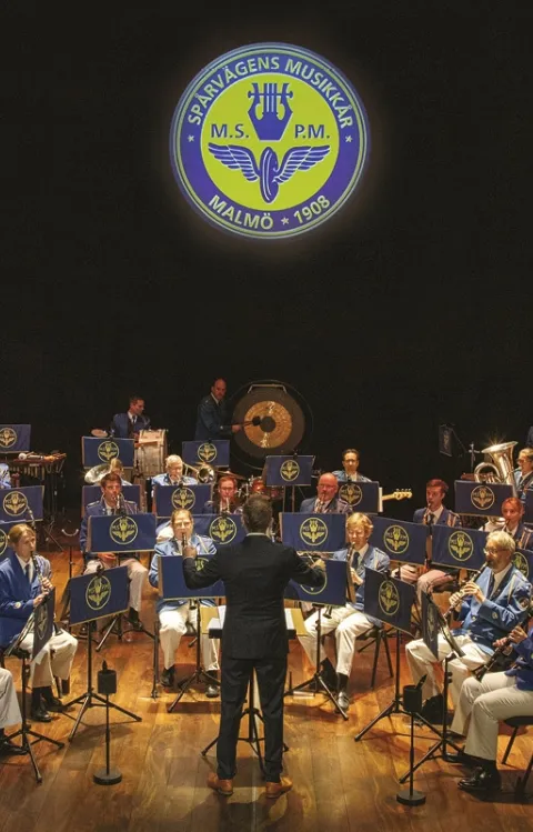 Spårvägens Musikkår i Malmö på scen under en höstkonsert tillsammans med sångsolisten Hedvig Becke.
