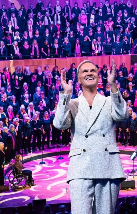 Kören happy voices i bakgrunden med Uno Sveningsson och Gabriel Forss