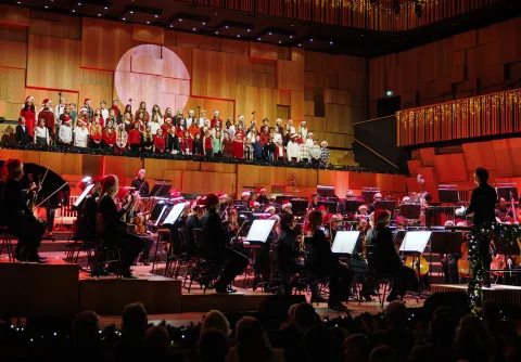 Konsertbild från en julkonsert, med julklädd orkester och kör