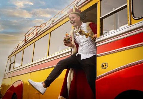 Conrad Molden med krona på huvudet på väg ut ur en buss