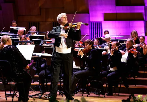 En orkester på scenen tillsammans med en solist som spelar violin till konserten Mozart unlimited med Malmö Symfoniorkester.