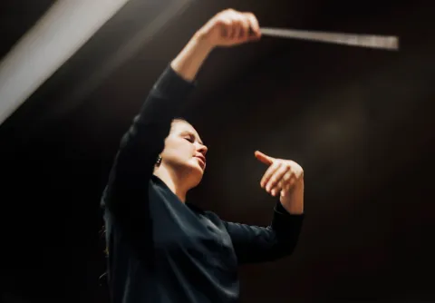 Person med händerna uppe i rörelse till konserten Sibelius och Tanaka med Malmö Symfoniorkester.