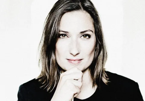 En kvinna med axellångt hår står framför en ljus bakgrund till konserten Vinterdrömmar med Malmö Symfoniorkester.