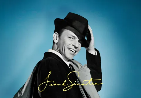 Frank Sinatra med svart hatt och stort leende