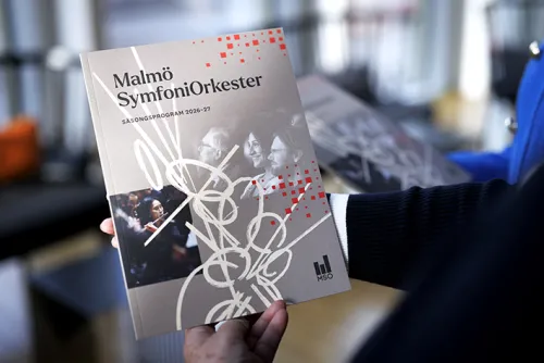 Säsongsprogrammet för Malmö SymfoniOrkester 2026-27, bild på en person som håller programmet